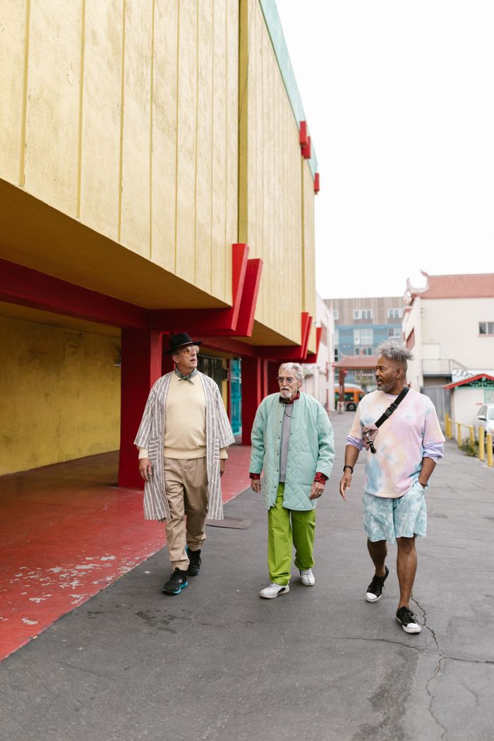 Three senior men walking in colorful outfits, showcasing street style and diverse fashion.